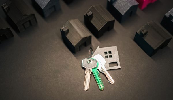 Miniature house models and keys symbolize real estate investment and housing market.
